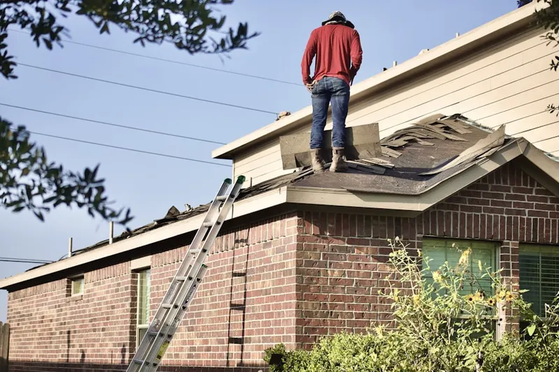 Professional roofer working on a residential roof in Grants